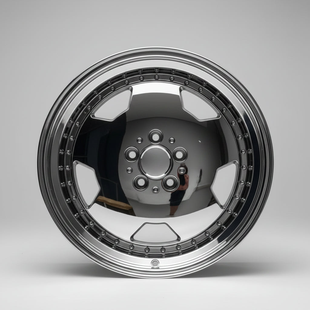 A polished chrome aftermarket car wheel rim with a multi-spoke design and decorative outer lip, photographed on a white surface against a white wall.