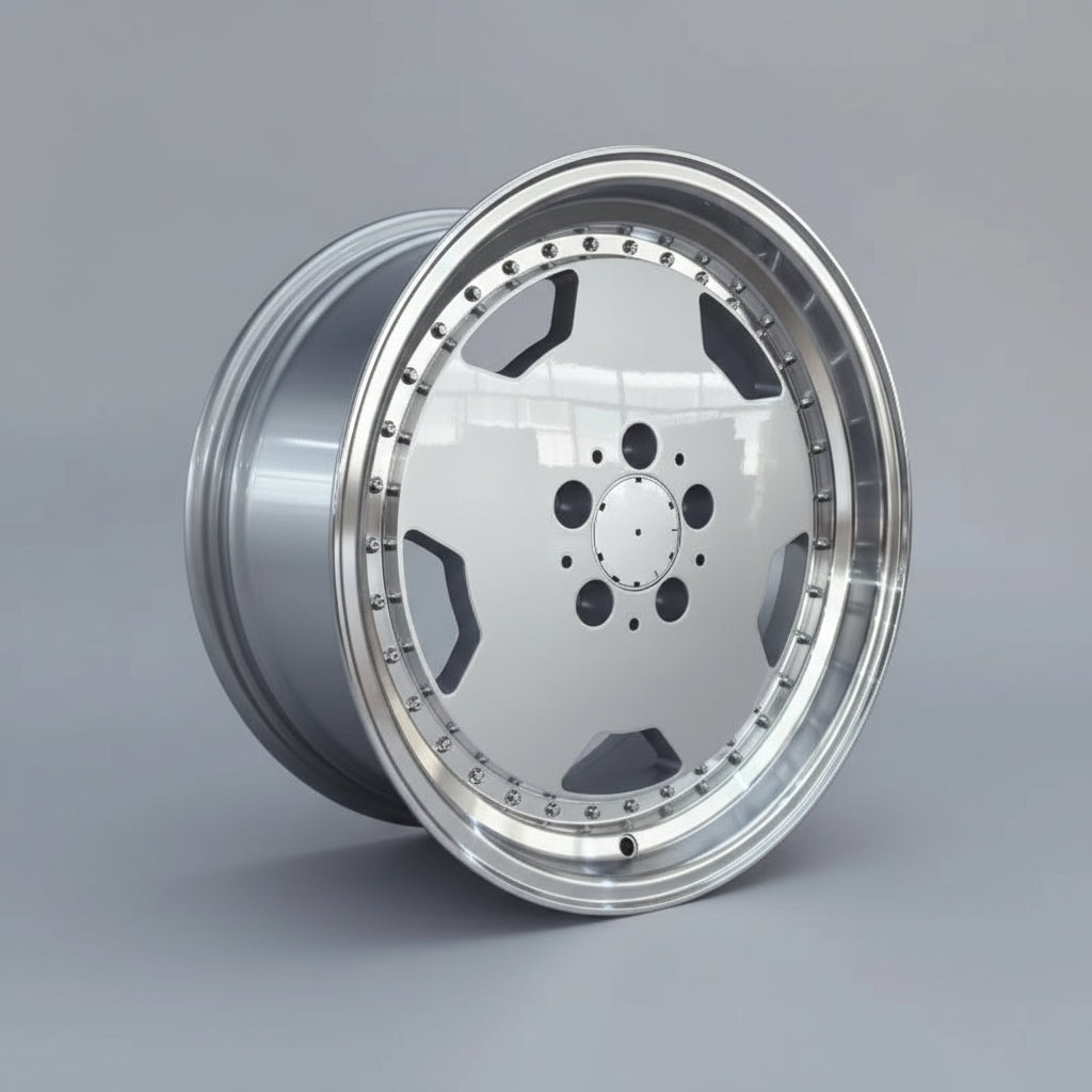 A polished silver alloy wheel rim with a multi-spoke design and decorative rivet details, displayed on top of cardboard boxes in a warehouse setting.