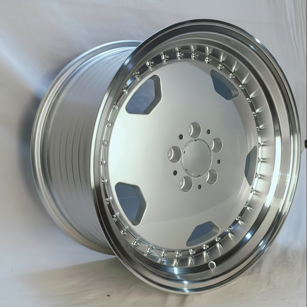 A polished silver multi-spoke alloy wheel rim photographed on a light fabric background.